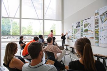 students in class with architecture projects on wall
