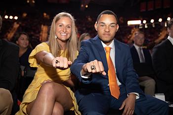 two students showing off their rings at ceremony